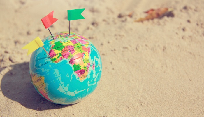 Travel summer Concept With Earth Map Ball on saNd