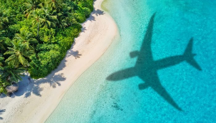plane flying over a tropical island