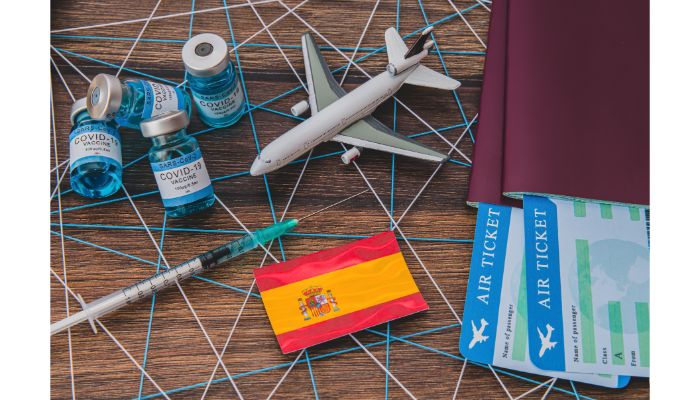 a toy airplane and passport with syringe and vaccine