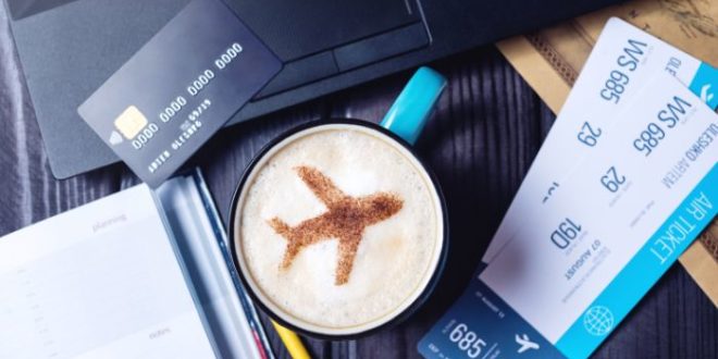 Credit card and plane on a coffee with flight tickets