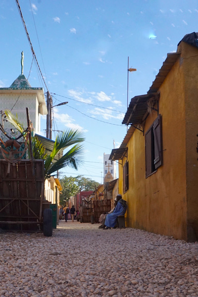 One of the narrow alleys of Seashell Island with locals relaxing in the shade