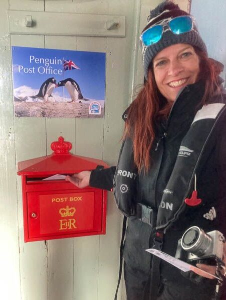 Posting a postcard in the postbox at Port Lockroy in Antarctica