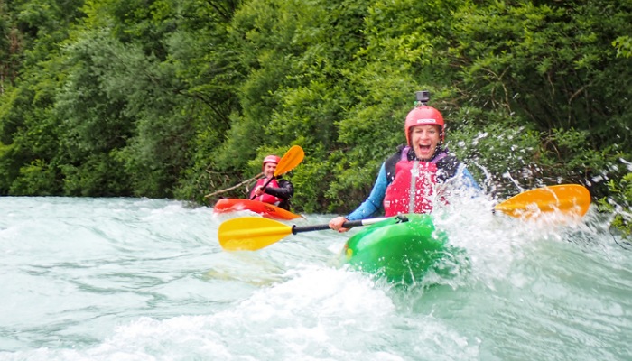 a couple of people in kayaks in a river