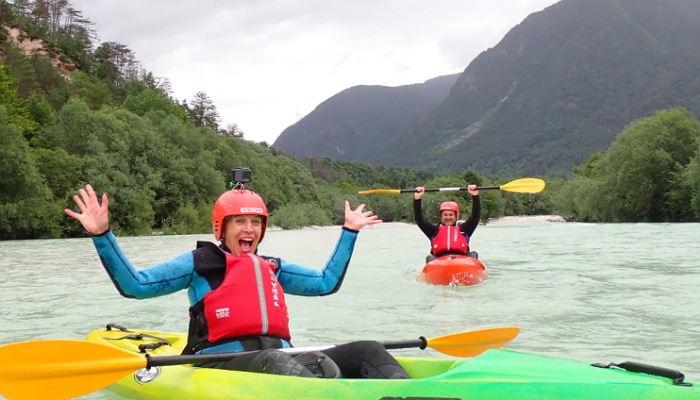 a couple of people in kayaks in a river