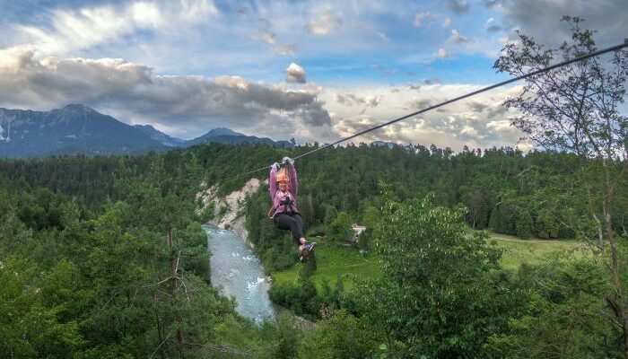a person on a zipline over a river