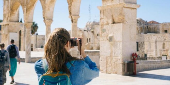 a woman taking a picture of a building