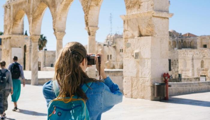 a woman taking a picture of a building