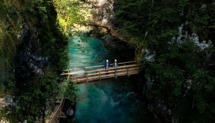 people standing on a bridge over the Vintgar Gorge