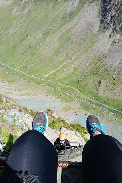 a person's legs and feet above a valley