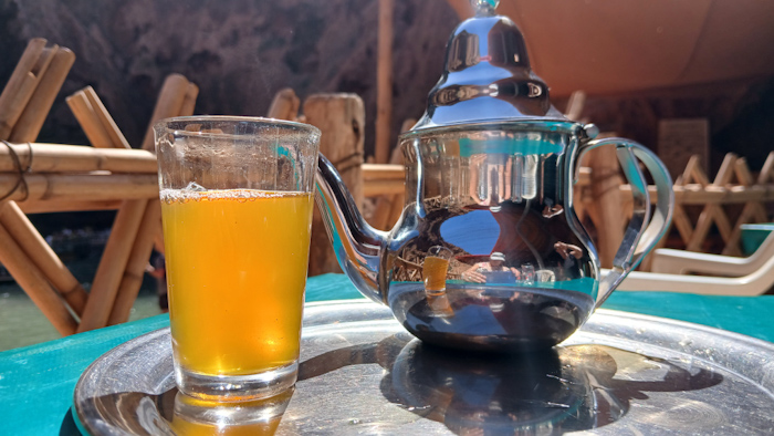 a teapot and a glass of liquid on a tray