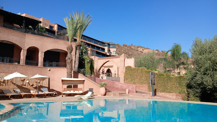 a pool with a building and palm trees