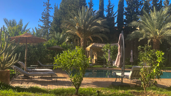 a pool with lounge chairs and umbrellas