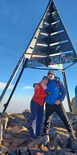 a man and woman standing under a metal structure