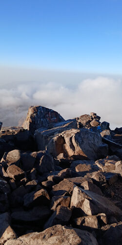 a rocky mountain with clouds in the background