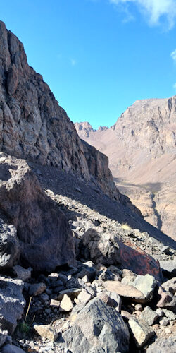 a rocky mountain side with blue sky