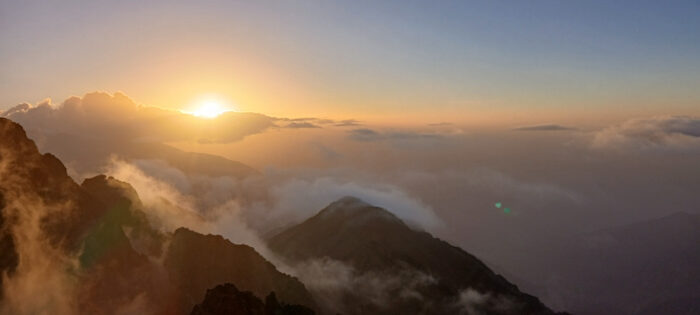 a sun setting over a mountain range