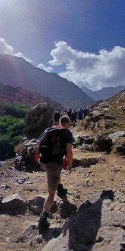 a man walking on a rocky path with a group of people